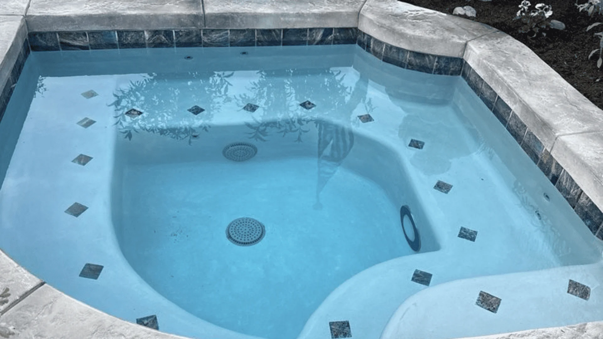 A newly installed pool pump and filter system mounted on a concrete pad beside a residential in-ground pool in Rialto, CA. Clean plumbing lines and electrical conduit connect the equipment pad to the pool in a tidy backyard setting.